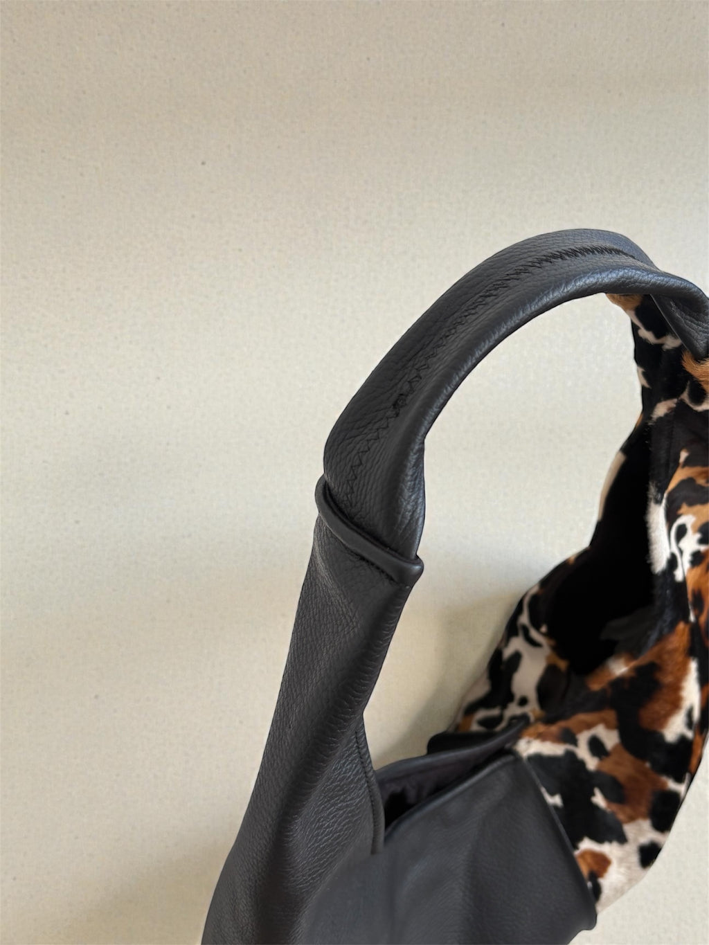 Borsa Reborn - cavallino muccato & pelle martellata nera